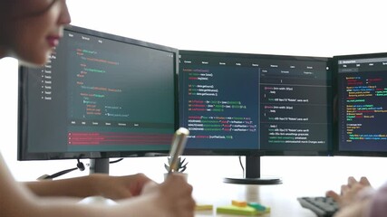 Slow motion back end software developer engineer for computer programming working together on debugging writing computing code, solving complex algorithms display on monitor in office. Burgeoning