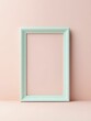 © Kanisorn - An empty mint green frame stands out against a soft pink background