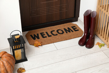 Wall Mural - Door mat with boots and autumn decor in hallway