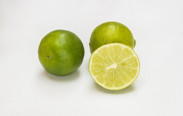 Fresh green limes with one cut open to show inside pulp