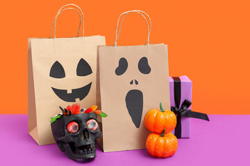 Wall Mural - Paper shopping bags, decorations and sweets for Halloween on color background