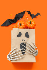 Poster - Composition with paper shopping bag and decorations for Halloween on orange background