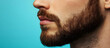 © Earny - Close-up of a man's profile showcasing a well-groomed beard against a vibrant blue background.