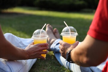 Canvas Print - Couple spending time together on green lawn in park, closeup