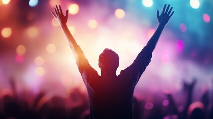 A man is standing in front of a crowd of people, with his arms raised in the air