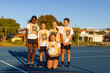 © Austockphoto - five children from netball team gathered together on blue playing surface for photo