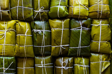 Top table view of background of hallacas, venezuelan traditional christmas food. Banana leaf and corn dough stuffed with a stew of beef. Latin american dish.