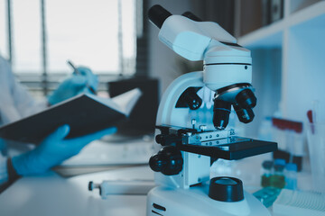 Wall Mural - a scientist uses a microscope to look for contaminants in a test sample, a researcher uses a microsc
