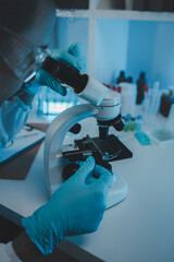 Wall Mural - a scientist uses a microscope to look for contaminants in a test sample, a researcher uses a microsc