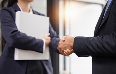 Team of Asian business people shaking hands meeting in office, Startup projects, Business partners handshaking after successful negotiations or signing contract.