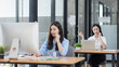 © SOMKID - Young asian businesswoman with headset using desktop computer for customer support and online working in office, Call center helping for customers online concept.