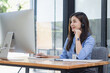 © SOMKID - Young asian businesswoman with headset using desktop computer for customer support and online working in office, Call center helping for customers online concept.