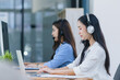 © SOMKID - Young asian businesswoman with headset using desktop computer for customer support and online working in office, Call center helping for customers online concept.