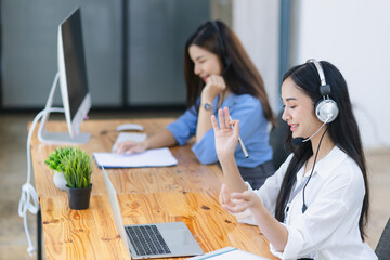 Young asian businesswoman with headset using desktop computer for customer support and online working in office, Call center helping for customers online concept.