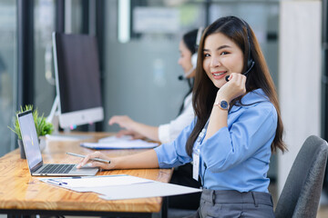 Young asian businesswoman with headset using desktop computer for customer support and online working in office, Call center helping for customers online concept.