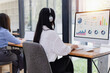 © SOMKID - Asian businesswoman with headset using desktop computer with analysis report and showing plan on desk in office. Digital marketing and finance performance indicators on screens concept.