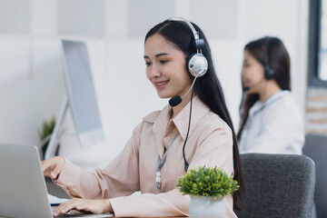 Young asian businesswoman with headset using desktop computer for customer support and online working in office, Call center helping for customers online concept.