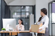 © SOMKID - Young asian woman employee with a storage box for the equipment after resigning and stressed from work.
