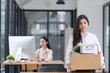 © SOMKID - Young asian woman employee with a storage box for the equipment after resigning and stressed from work.
