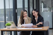 © SOMKID - Two Asian businesswomen working on laptop computer with analyzing financial charts in the modern office, Business financial documents and planning idea project concept.