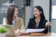 © SOMKID - Two Asian businesswomen working on laptop computer with analyzing financial charts in the modern office, Business financial documents and planning idea project concept.
