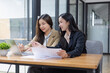 © SOMKID - Two Asian businesswomen working on laptop computer with analyzing financial charts in the modern office, Business financial documents and planning idea project concept.