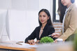 © SOMKID - Two Asian young businesswomen working on computer with analyzing financial charts in the modern office, Business financial documents and planning idea project concept.