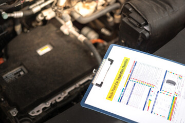 Wall Mural - a multi-point car maintenance and inspection checklist paper on clipboard, that placed at car front 