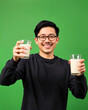 © AnggiDimas - Portrait young man holding glass of milk happy smiling