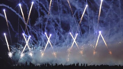 Wall Mural - Crowd of people watch Breathtaking spectacle of international fireworks festival as vibrant colors explode against night sky. Dazzling display encompasses a wide array of shapes and patterns