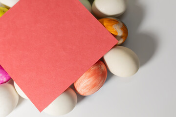 Colorful easter eggs with red blank card on white background