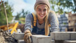 © Stefan - Cheerful female bricklayer or mason happy smiling Caucasian young woman building a wall or architectural building with bricks and cement industry construction worker working with stone blocks outdoors