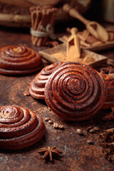 Cinnamon buns on a brown kitchen table.