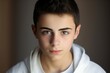 © MediaRaw - A young man with brown hair and brown eyes is wearing a white hoodie