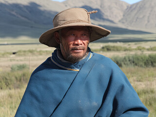 Portrait of a Mongolian nomad in traditional deel and hat, Mongolia