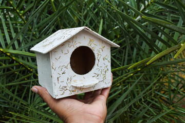 Small bird standing on wooden birdhouse in spring garden, A small painted wooden birdhouse isolated on a white background