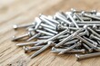 © Salander Studio - close-up shot of a scattered pile of metallic nails on a wooden table