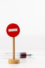 Blood-Filled Syringe and Wooden Sign