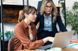 © Westend61 - Businesswoman discussing with colleague on laptop in office