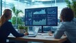 © bird_saranyoo - Colleagues gathered around a large monitor, discussing analytics and making data-driven decisions together.
