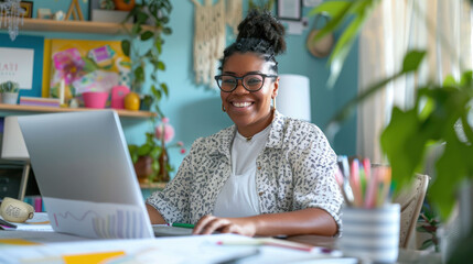 Fototapete - A smiling woman working on laptop in colorful home office, surrounded by plants and stationery.