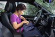 © toa555 - Senior asian woman sitting on drivers seat and look for a key inside handbag.