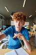 © Mediaphotos - Vertical portrait of young red haired man holding camera and talking to video chat POV