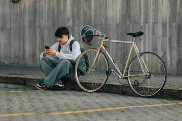 Poster - urban scene of young man with mobile phone and vintage bicycle