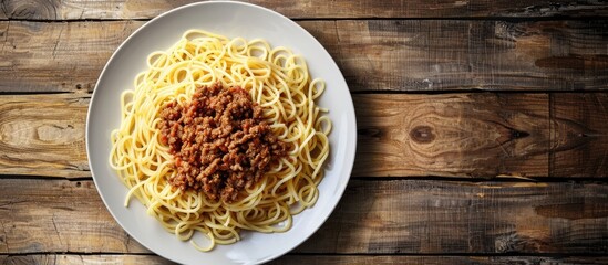Poster - A plate with pasta and minced meat is displayed on a wooden table with copy space image