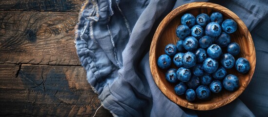 Poster - Top view close up of blueberries displayed on a wooden plate against a rustic cloth background with a blank space for text in the image. Creative banner. Copyspace image