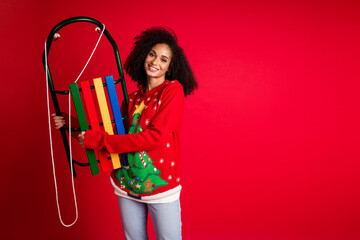 Sticker - Photo of lovely charming girl wear red pullover hold sledge xmas magic miracle party empty space isolated on red color background