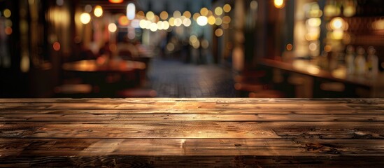 A wooden table is displayed in a blur of a modern night scene at a bustling restaurant offering a generous copy space image for presenting products or food