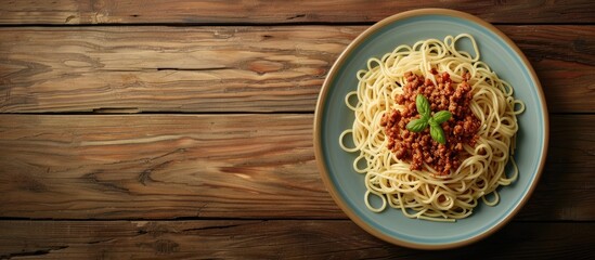 Poster - A plate with pasta and minced meat is displayed on a wooden table with copy space image