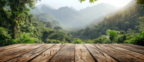Poster - Wooden table with a blurred backdrop of mountains and lush greenery providing a copy space image for displaying products against a stunning forest landscape